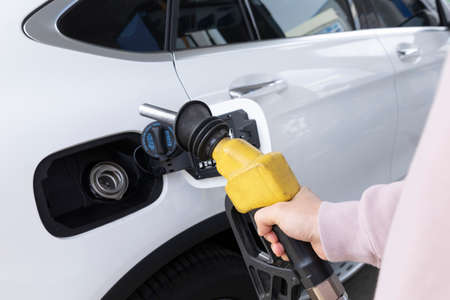hand holding fuel nozzle at gas station