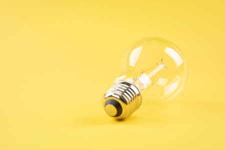 Transparent light bulb on yellow backgroundの写真素材