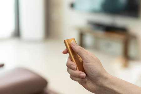 hand turning on home gadget using remote control