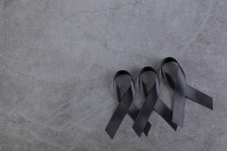 Black ribbons on dark cement background