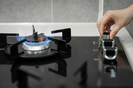 hand turning on gas stoveの写真素材