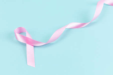 Pink ribbon on a mint color backgroundの写真素材