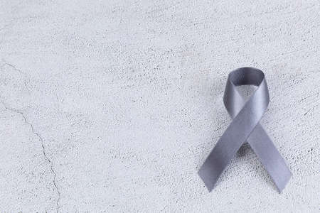 Gray ribbon on cement background