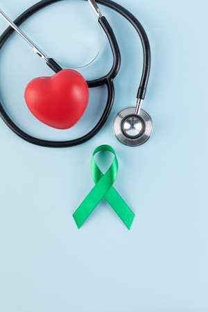 stethoscope, heart and green ribbon, sky blue backgroundの写真素材