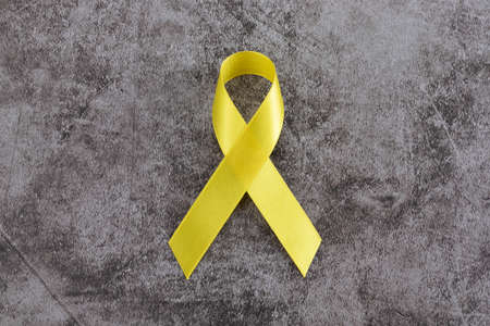 Yellow ribbon on dark cement backgroundの写真素材