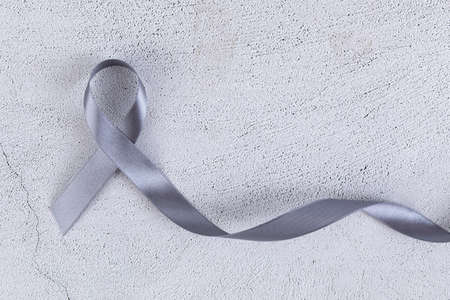 Gray ribbon on cement background