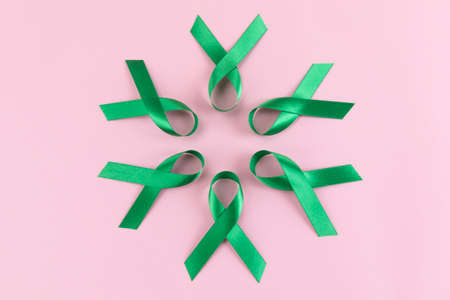 Green ribbons in circle on pink backgroundの写真素材