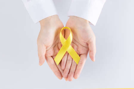 person with white shirt holding yellow ribbon