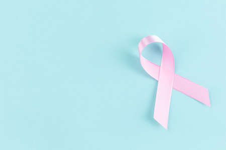 Pink ribbon on a mint color backgroundの写真素材