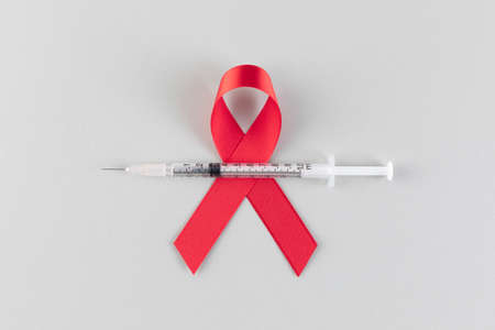 Red ribbon with syringe, gray backgroundの写真素材
