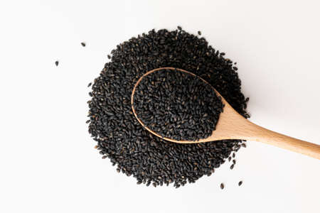 Wooden spoon with black sesame, white backgroundの写真素材