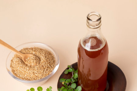 sesame seed in glass bowl with wood spoon and sesame oil bottleの写真素材