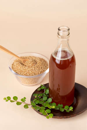 sesame seed in glass bowl with wood spoon and sesame oil bottleの写真素材