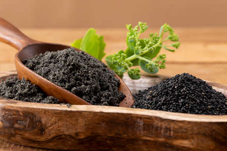 Black sesame seeds filled with wooden bowl and spoonの写真素材