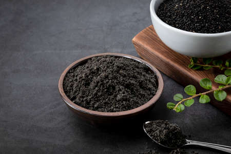 black sesame seed and powder in porcelain and spoonの写真素材