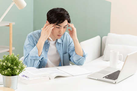 untact online education, tired Asian man college student studying with laptop