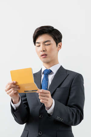Asian man employee checking his balance in bank bookの写真素材