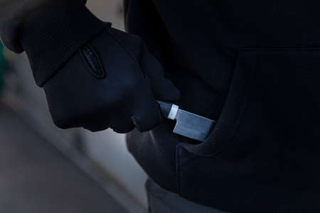 criminal taking out knife from pocket