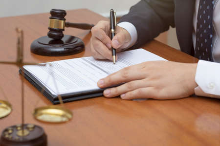 hand of legal profession on papers, gavel, justice of scale