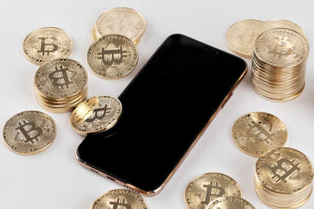 smartphone surrounded by bitcoinの写真素材