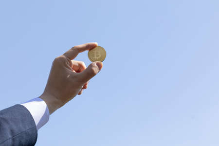 bitcoin in businessman, clear sky backgroundの写真素材