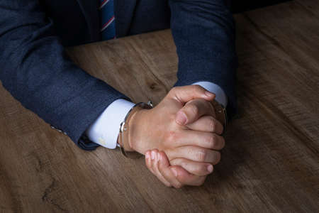 business crime concept, handcuffed criminal in suit