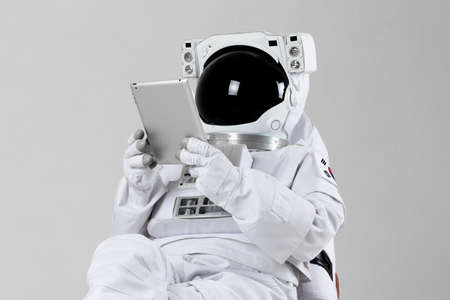 astronaut surfing Internet with tablet PC, white backgroundの写真素材