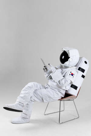 astronaut surfing Internet with tablet PC, white backgroundの写真素材