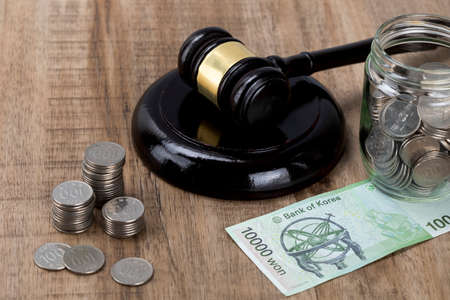 Crime and law - glass bottles filled with coins Banknote and gavelの写真素材