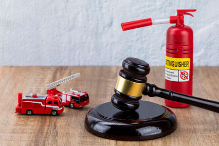 Crime and law - miniature fire car, fire extinguishers and gavel