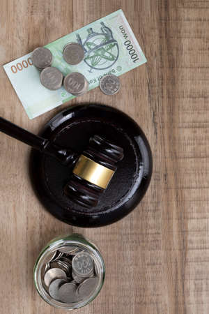 Crime and law - glass bottles filled with coins Banknote and gavelの写真素材