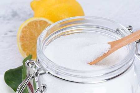 Zero waste cleaning - powdered citric acid, wood spoon and lemonの写真素材