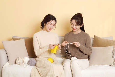asian korean women best friends enjoying knitting hobbyの写真素材