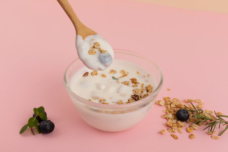 scooping yogurt with a spoon, pink backgroundの写真素材