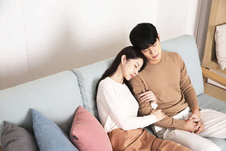 sweet Asian Korean couple on sofa