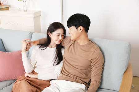 sweet Asian Korean couple on sofa