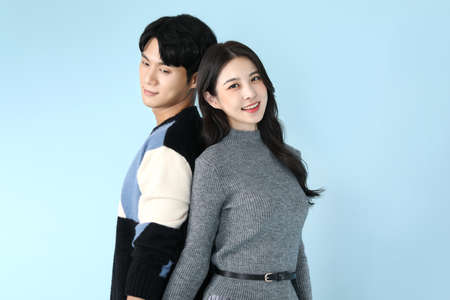 Asian Korean couple in FW fashion, studio background holding handsの写真素材