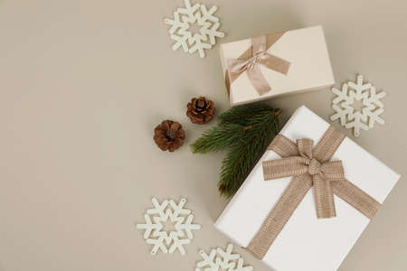 beige background with gift box, pine cone and snow ornamentsの写真素材
