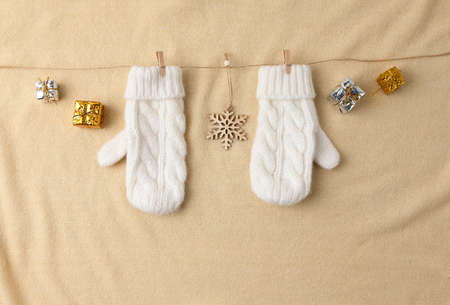 CHristmas ornaments and gift box, gloves in white fabric background