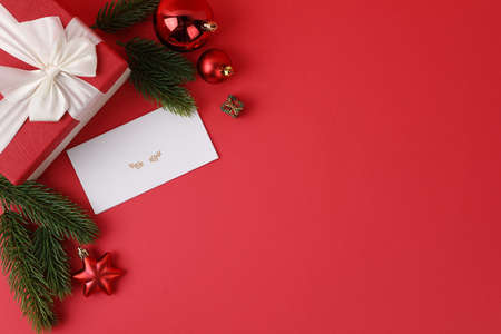 Christmas gift box and ornaments in red background