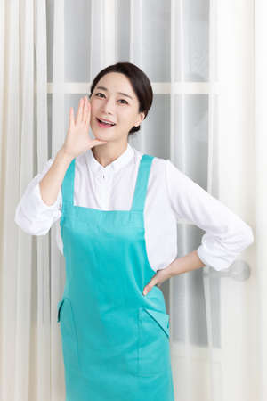 Asian woman wearing white shirt and apron, professional home cleaning service jobの写真素材