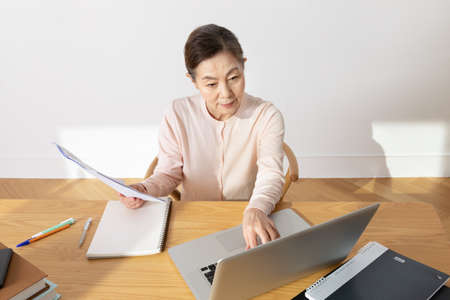 asian senior studying with a laptop