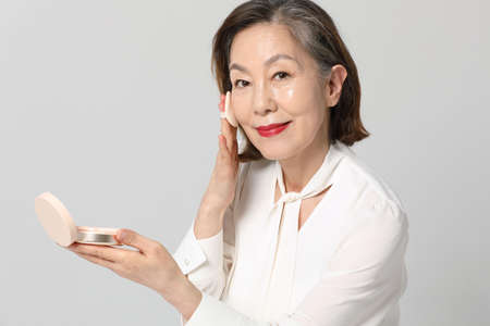 Asian Korean senior woman, bold and red cosmetics makeup beauty concept in studioの写真素材