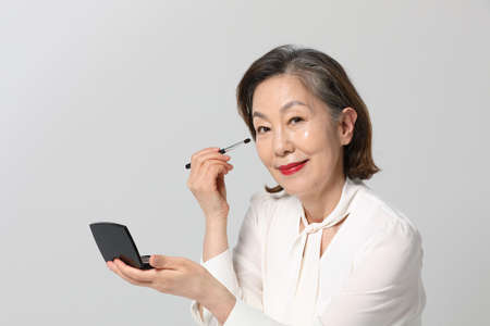 Asian Korean senior woman, bold and red cosmetics makeup beauty concept in studioの写真素材