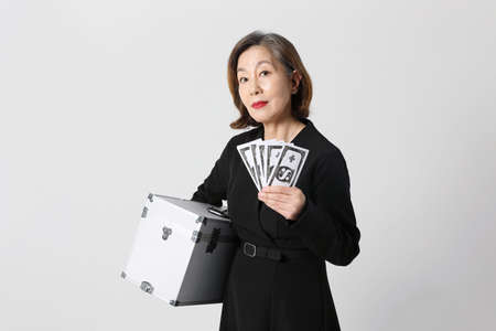 fashionable Asian Korean senior woman, holding cashの写真素材