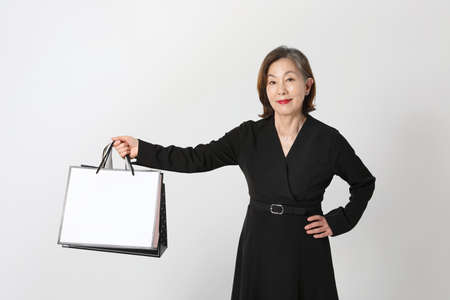 fashionable Asian Korean senior woman, holding a shopping bagの写真素材