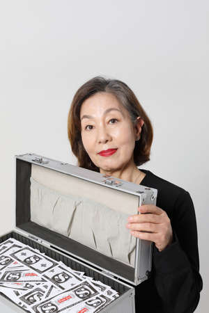 fashionable Asian Korean senior woman, holding cashの写真素材