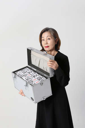 fashionable Asian Korean senior woman, holding cashの写真素材