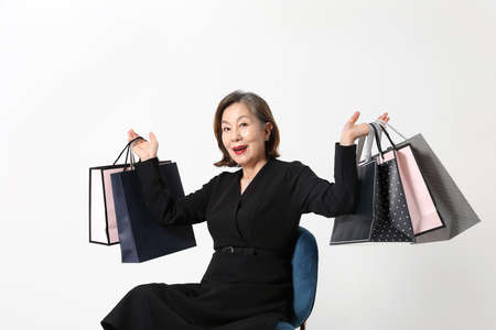 fashionable Asian Korean senior woman, holding a shopping bagの写真素材