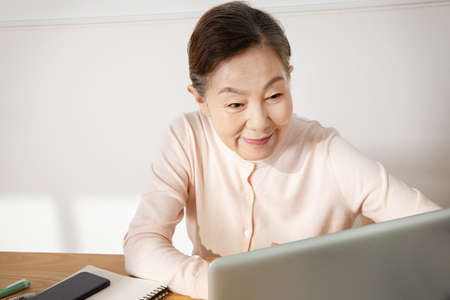 Asian Korean senior woman studying with a laptopの写真素材